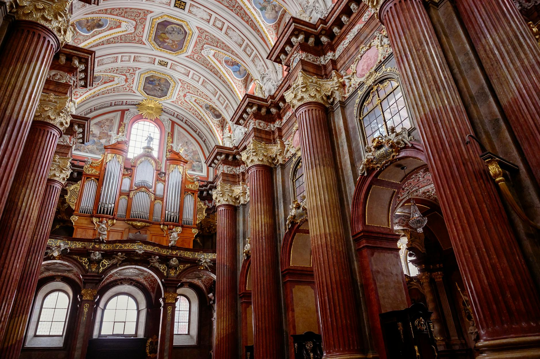 Barokowe wnętrze kościoła z kolumnami, bogatymi zdobieniami i wielkimi organami