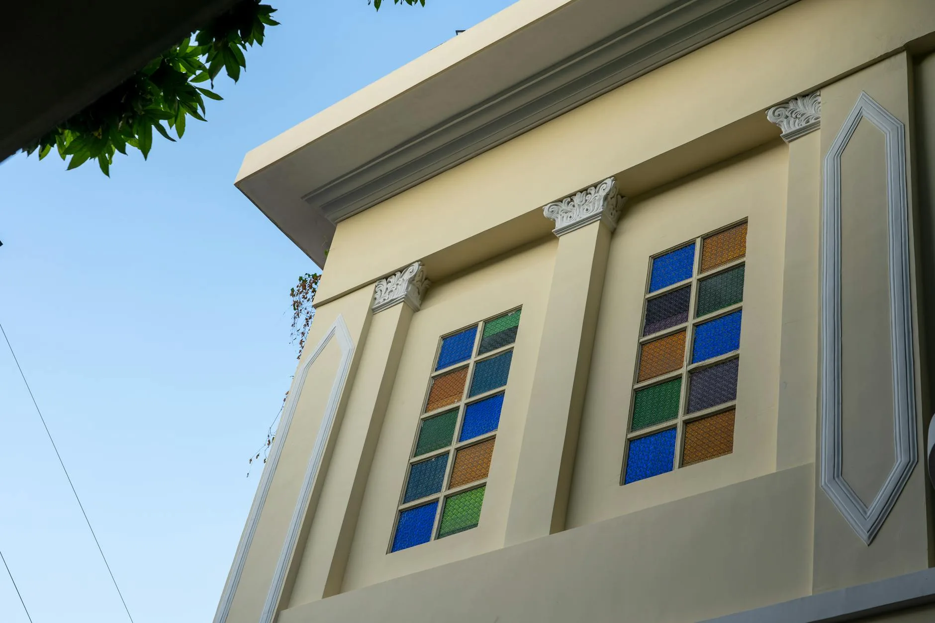 Kolorowe okna witrażowe na eleganckiej fasadzie kamienicy