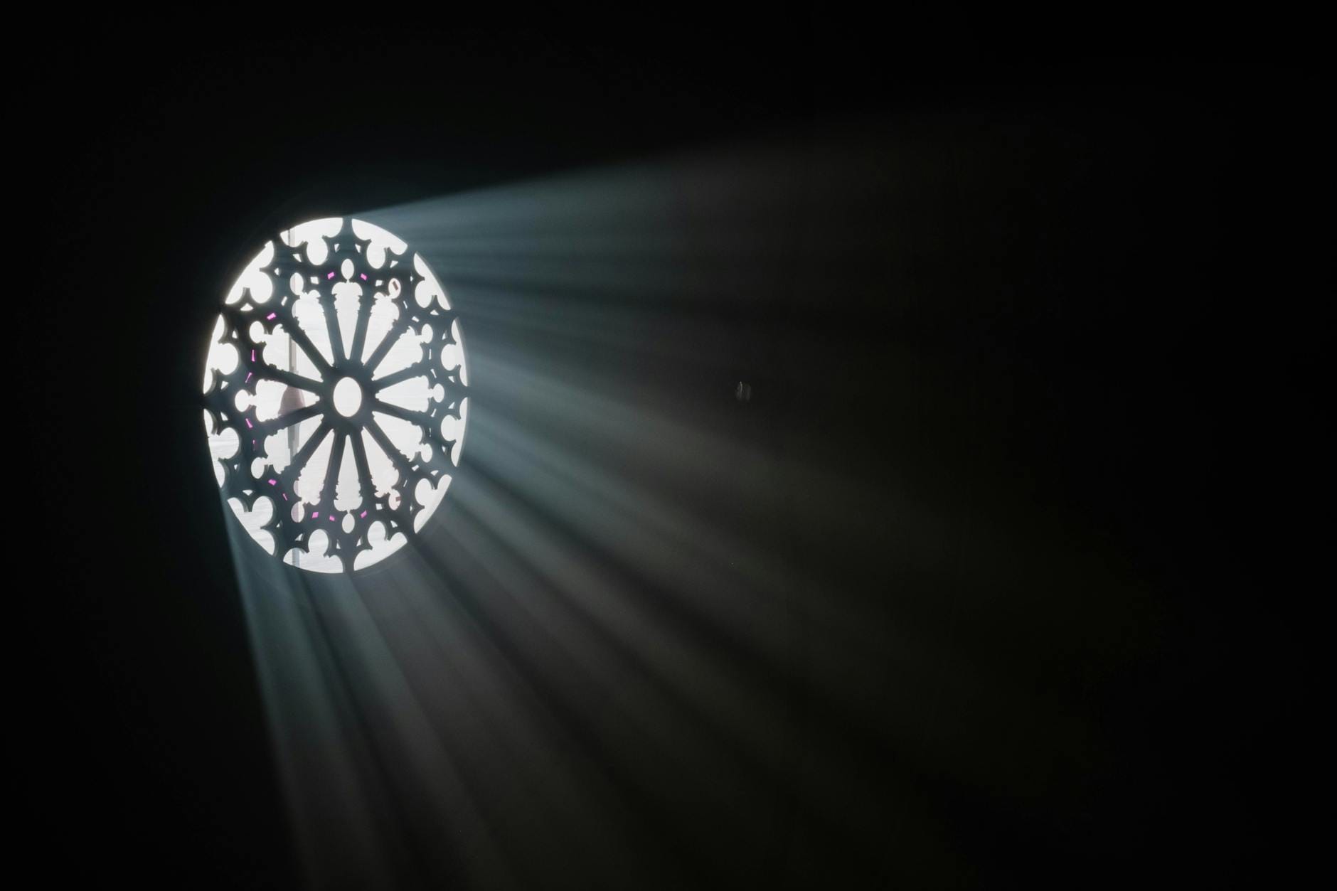 Promienie słońca przechodzące przez kolorowe witraże Sagrady Familii