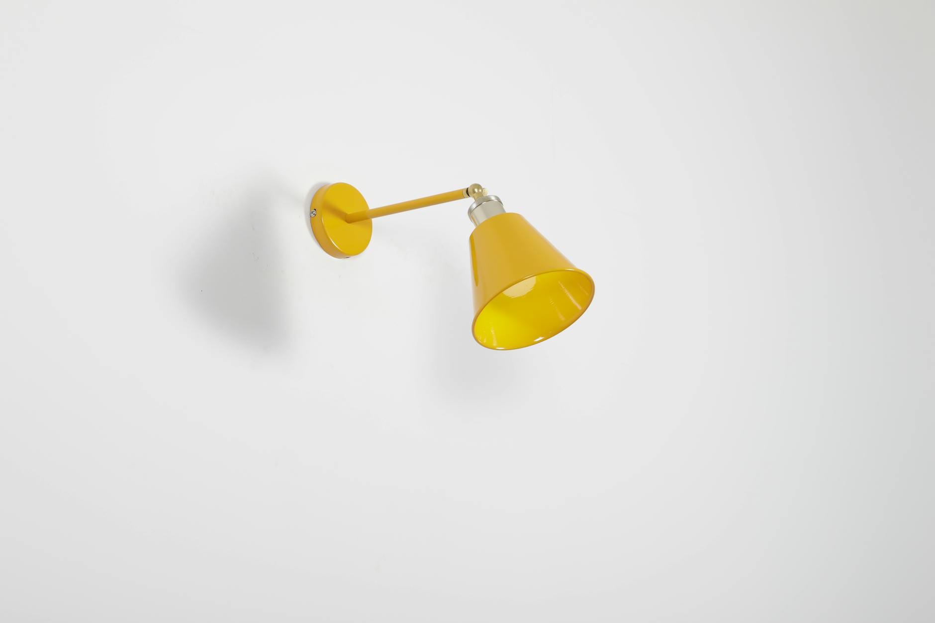 Nowoczesna żółta kinkietowa lampa na białej ścianie