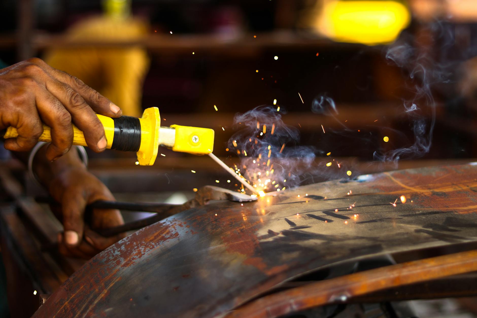 Spawacz w warsztacie, zbliżenie na iskry podczas precyzyjnej pracy