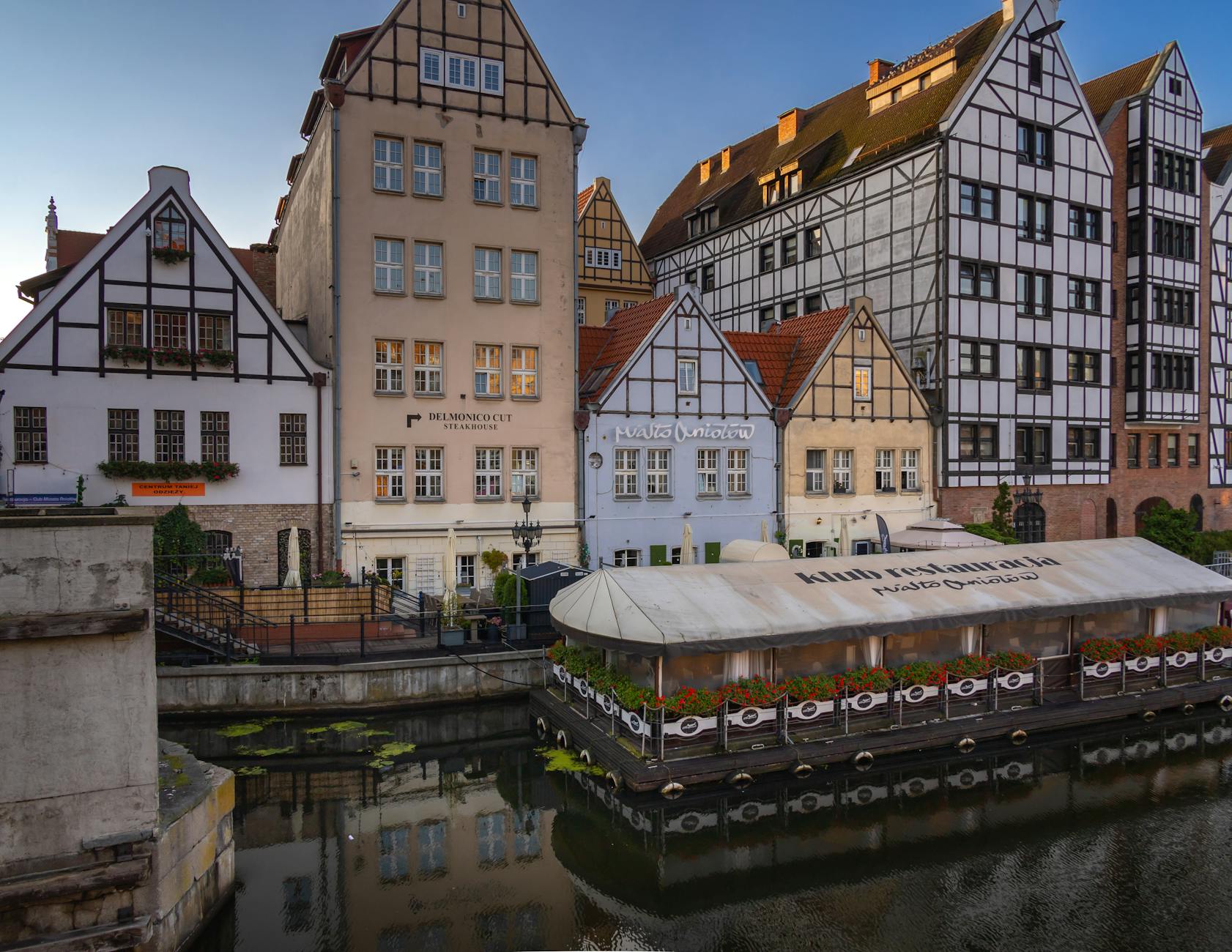 Kamienice nad Motławą w Gdańsku odbijające się w spokojnej wodzie