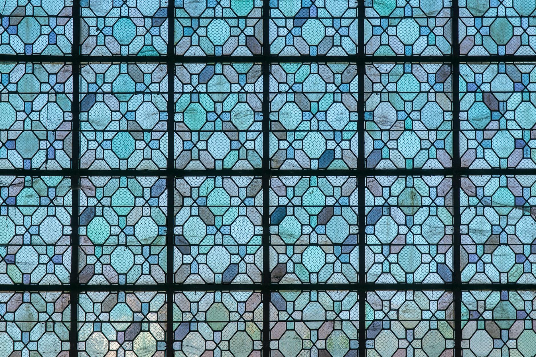 Niebieskie geometryczne wzory witraża złożone z symetrycznych plecionek